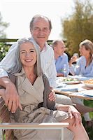 Portrait of smiling senior couple enjoying lunch with friends at table in sunny garden Stock Photo - Premium Royalty-Freenull, Code: 635-05656228