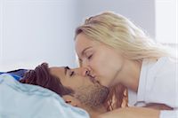 Intimate young couple kissing each other lying in the bed Stock Photo - Premium Royalty-Free, Artist: Blend Images, Code: 6109-07497311