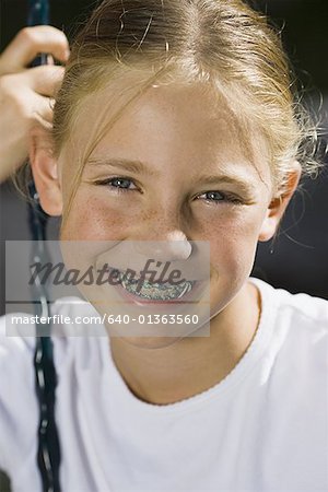 Portrait of a girl sitting on a swing - Stock Photo - 640-01363560em