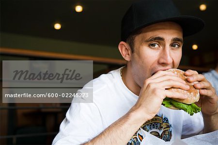 Man Eating Hamburger Stock Photo - Premium Royalty-Free, Artist: Patrick Chatelain, - 600-02245273em