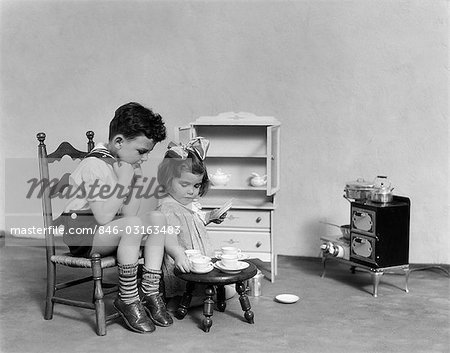 1930s TWO CHILDREN PLAYING HOUSE TEA PARTY - Stock Photos