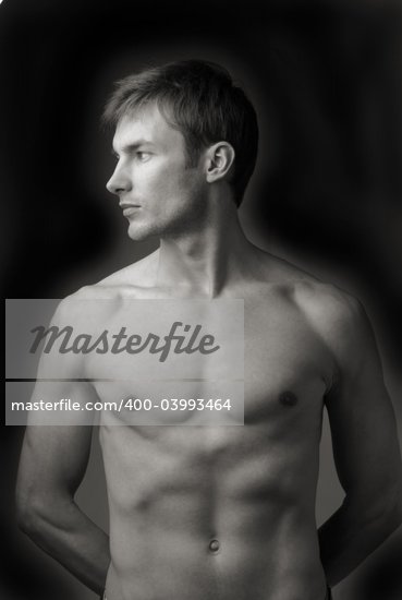 portrait young naked men which looks aside on dark background