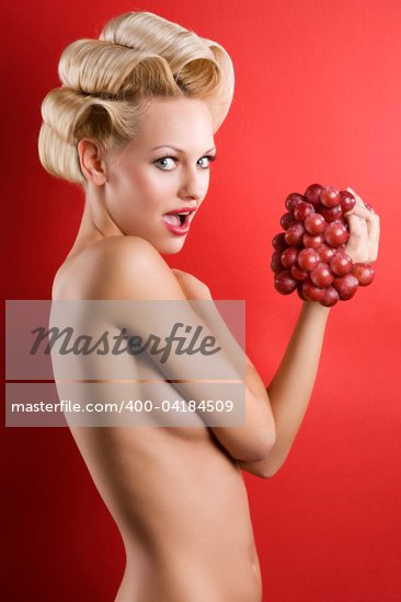 blond and graceful naked girl on red with some red grape