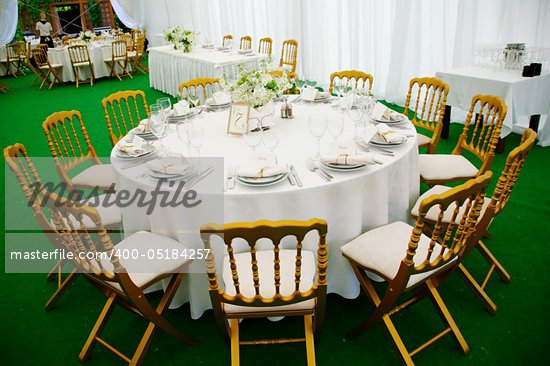 A view of a round banquet table with napkins and silverware set and a 