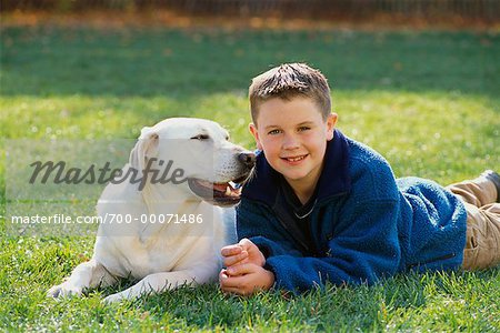  - 700-00071486em-Portrait-of-Boy-Lying-in-Field-With-Dog-in-Autumn---