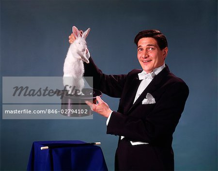 846-02794102em-MAGICIAN-MAN-BLACK-COAT-BLUE-BACKGROUND-PULLING-RABBIT-OUT-OF-TOP-HAT-.jpg