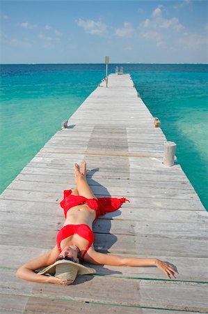 simsearch:400-03950469,k - One of a large series. Woman in red bikini sunbathing on a tropical jetty Stock Photo - Budget Royalty-Free & Subscription, Code: 400-04018672