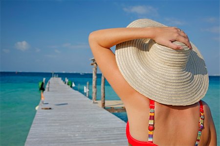 simsearch:400-03950469,k - One of a large series. Woman in red bikini walking down a tropical jetty Stock Photo - Budget Royalty-Free & Subscription, Code: 400-04019096