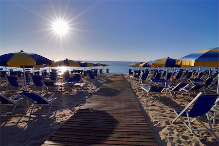 simsearch:400-07553490,k - Empty beach with umbrellas and sun shortly after the sunrise Stock Photo - Budget Royalty-Free & Subscription, Code: 400-04010263