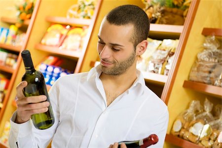 simsearch:400-04012842,k - man in a supermarket comparing two wines Stock Photo - Budget Royalty-Free & Subscription, Code: 400-04011950