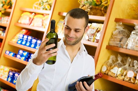 simsearch:400-04012842,k - man in a supermarket comparing two wines Stock Photo - Budget Royalty-Free & Subscription, Code: 400-04012844