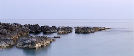 A serene panoramic picture of coastline rocks in calm waters Stock Photo - Budget Royalty-Free & Subscription, Code: 400-04028997