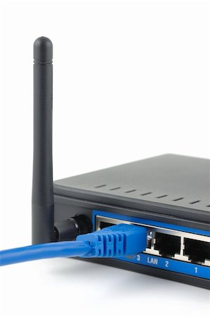 Blue network cable connected to a wireless router over white background Foto de stock - Super Valor sin royalties y Suscripción, Código: 400-04022610