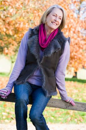 simsearch:400-04035087,k - Senior woman sitting on fence with autumn trees behind Stock Photo - Budget Royalty-Free & Subscription, Code: 400-04035046