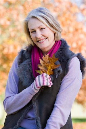 simsearch:400-04035087,k - Senior woman holding autumn leaf with trees in background Stock Photo - Budget Royalty-Free & Subscription, Code: 400-04035047
