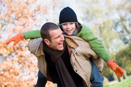 simsearch:400-04035087,k - Father giving son piggyback through autumn woods Stock Photo - Budget Royalty-Free & Subscription, Code: 400-04035086