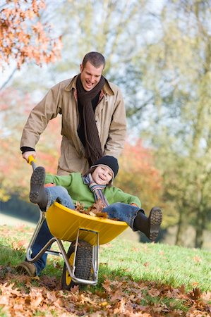 simsearch:400-04035087,k - Father giving son ride in wheelbarrowe through autumn leaves Stock Photo - Budget Royalty-Free & Subscription, Code: 400-04035081