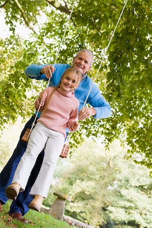 simsearch:400-04035087,k - Grandfather pushing granddaughter on garden swing Stock Photo - Budget Royalty-Free & Subscription, Code: 400-04035092
