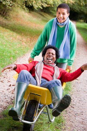 simsearch:400-04035087,k - Son pushing laughing mother in wheelbarrow Stock Photo - Budget Royalty-Free & Subscription, Code: 400-04035100