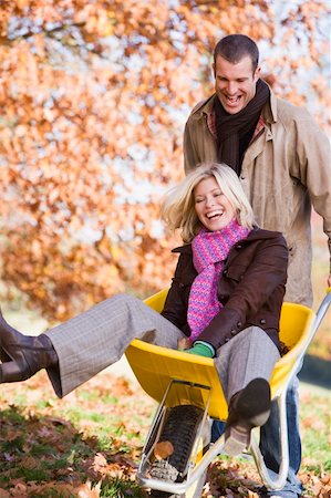 simsearch:400-04035087,k - Man pushing woman in wheelbarrow through autumn leaves Stock Photo - Budget Royalty-Free & Subscription, Code: 400-04035135