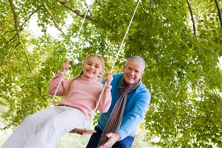 simsearch:400-04035087,k - Grandfather pushing granddaughter on garden swing Stock Photo - Budget Royalty-Free & Subscription, Code: 400-04035138