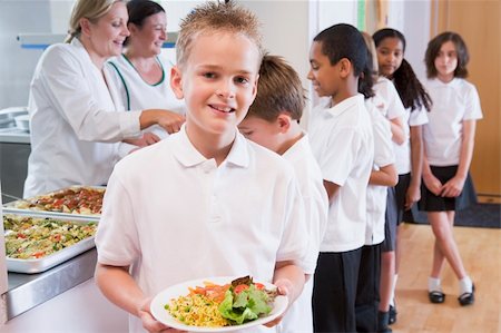 Schoolboy holding plate of lunch in school cafeteria Stock Photo - Budget Royalty-Free & Subscription, Code: 400-04036572