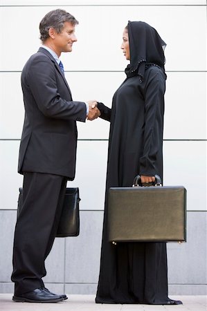 A Middle Eastern businesswoman shaking hands with a Caucasian bu Stock Photo - Budget Royalty-Free & Subscription, Code: 400-04037090