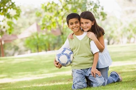 Two children playing football in park looking to camera Stock Photo - Budget Royalty-Free & Subscription, Code: 400-04038297