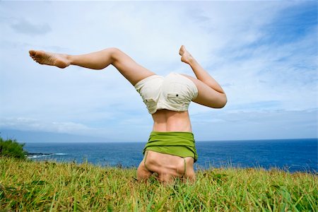 Young woman doing headstand with legs askew in grass near ocean in Maui, Hawaii. Stock Photo - Budget Royalty-Free & Subscription, Code: 400-04039578