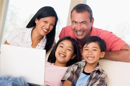 filipina mother daughter - Family in living room with laptop smiling Photographie de stock - Aubaine LD & Abonnement, Code: 400-04044101
