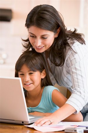 simsearch:400-05751173,k - Woman and young girl in kitchen with laptop and paperwork smilin Stock Photo - Budget Royalty-Free & Subscription, Code: 400-04044116