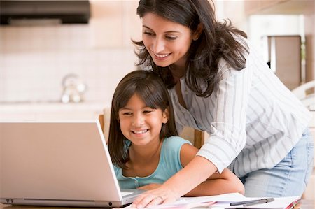 simsearch:400-05751173,k - Woman and young girl in kitchen with laptop and paperwork smilin Stock Photo - Budget Royalty-Free & Subscription, Code: 400-04044117