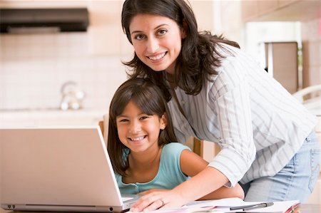 simsearch:400-05751173,k - Woman and young girl in kitchen with laptop and paperwork smilin Stock Photo - Budget Royalty-Free & Subscription, Code: 400-04044118