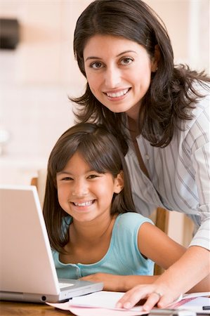 simsearch:400-05751173,k - Woman and young girl in kitchen with laptop and paperwork smilin Stock Photo - Budget Royalty-Free & Subscription, Code: 400-04044119