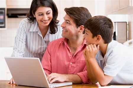 simsearch:400-05751173,k - Family in kitchen with laptop smiling Stock Photo - Budget Royalty-Free & Subscription, Code: 400-04044125