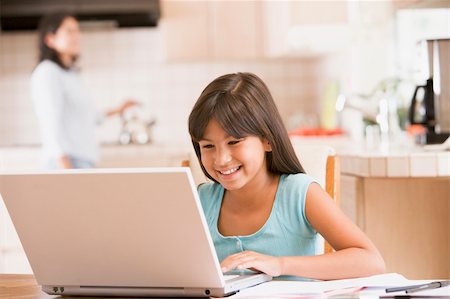 simsearch:400-05751173,k - Young girl in kitchen with laptop and paperwork smiling with wom Stock Photo - Budget Royalty-Free & Subscription, Code: 400-04044120