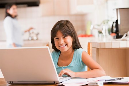 simsearch:400-05751173,k - Young girl in kitchen with laptop and paperwork smiling with wom Stock Photo - Budget Royalty-Free & Subscription, Code: 400-04044121