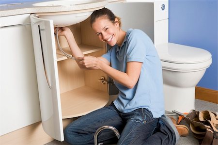 female plumber - Plumber working on sink smiling Stock Photo - Budget Royalty-Free & Subscription, Code: 400-04045107