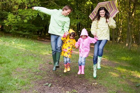 shower with sibling - Family outdoors skipping with umbrella smiling Stock Photo - Budget Royalty-Free & Subscription, Code: 400-04045369