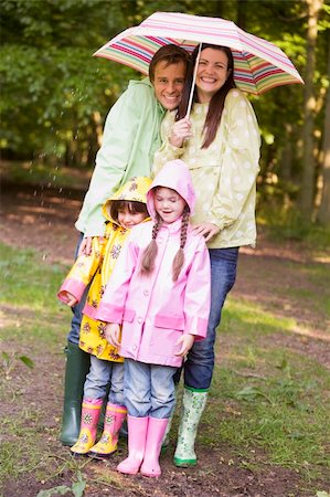 shower with sibling - Family outdoors in rain with umbrella smiling Stock Photo - Budget Royalty-Free & Subscription, Code: 400-04045372
