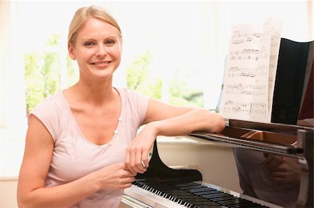 Woman sitting at piano and smiling Stock Photo - Budget Royalty-Free & Subscription, Code: 400-04046168