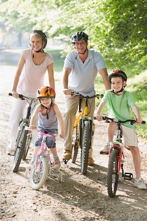 family mountain biking - Family sitting on bikes on path smiling Stock Photo - Budget Royalty-Free & Subscription, Code: 400-04042772