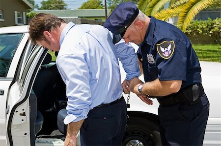 Businessman being handcuffed and placed under arrest. Stock Photo - Budget Royalty-Free & Subscription, Code: 400-04043500