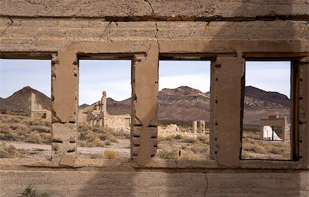 Rhyolite was a gold rush town in Nevada which was abandonded when the gold ran out.  This photo was taken through the windows of the school and shows a ruins of a bank and a store in the background. Stock Photo - Budget Royalty-Free & Subscription, Code: 400-04059670