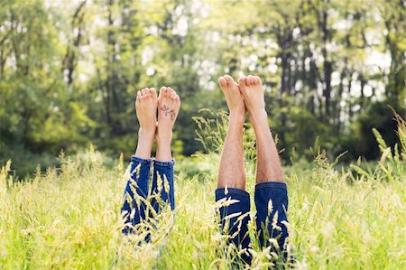 simsearch:400-03934248,k - Couple lying in grass stretching their legs up Stock Photo - Budget Royalty-Free & Subscription, Code: 400-04059848