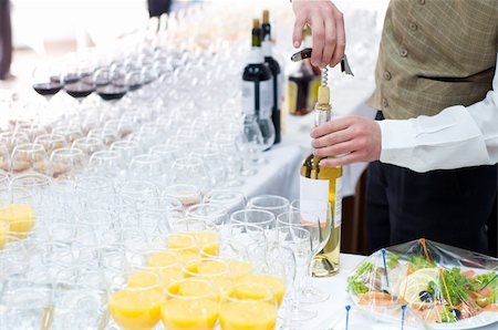 waiter unscrews cork from wine bottle before pouring Stock Photo - Budget Royalty-Free & Subscription, Code: 400-04052197