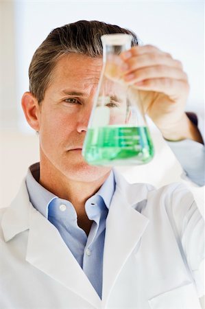 periodic table - scientist holding up jar of green chemicals Photographie de stock - Aubaine LD & Abonnement, Code: 400-04053445