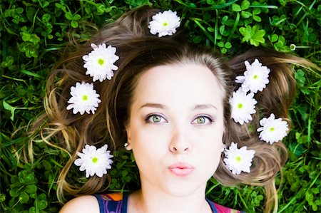 simsearch:400-05678958,k - Summer Kiss. Woman with flower in hair laying on grass. Photographie de stock - Aubaine LD & Abonnement, Code: 400-04069298