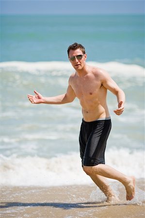 caucasian man running on the beach with sunglasses Stock Photo - Budget Royalty-Free & Subscription, Code: 400-04060370