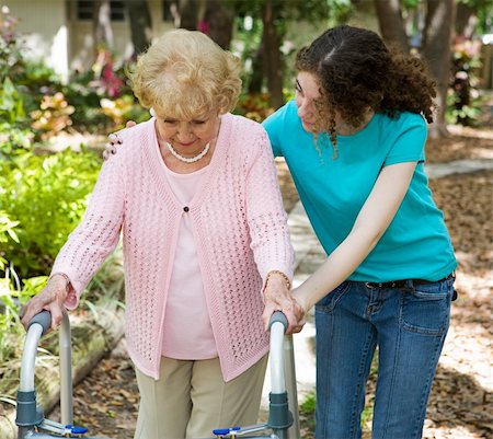 Senior woman struggles to walk with the help of a walker and her young granddaughter. Stock Photo - Budget Royalty-Free & Subscription, Code: 400-04061252